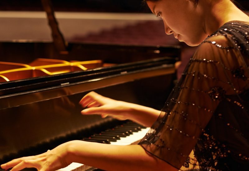 Entertaining the crowd. Shot of a young woman playing the piano during a musical concert.